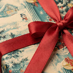 Vintage Christmas wrapping paper with a snowman pattern and red satin ribbon bow by Wrapped Studios.