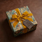 Gift box in unique architectural wrapping paper with gold velvet ribbon and "On the Move" tag.