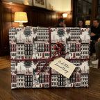 Vintage Christmas wrapping paper with NYC brownstone print, red twine, and tag by Wrapped Studios.