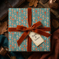 Christian cross baptism wrapping paper in teal and rust with a velvet bow by Wrapped Studios.