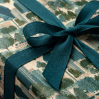 Luxury cityscape wrapping paper with a textured teal ribbon bow, by Wrapped Studios.
