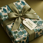 Luxury green birthday wrapping paper with cityscape pattern and sage ribbon by Wrapped Studios.