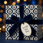 Luxury navy blue damask wrapping paper with a velvet bow and gift tag by Wrapped Studios.