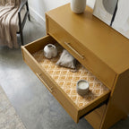 Vintage mustard floral wrapping paper used as a drawer liner in a modern dresser, by Wrapped Studios.