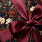 Luxury vintage floral wrapping paper with a burgundy satin bow by Wrapped Studios.
