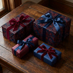 Luxury floral wrapping paper in navy and burgundy with velvet ribbons on gift boxes by Wrapped Studios.