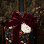 Luxury dark floral wrapping paper with a burgundy velvet ribbon and gift tag by Wrapped Studios.