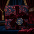 Luxury dark floral wrapping paper with a burgundy velvet bow and gift tag by Wrapped Studios.