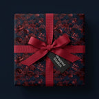 Luxury moody floral wrapping paper in burgundy and navy with a red bow by Wrapped Studios.