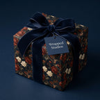 Luxury floral wrapping paper with a navy velvet bow and gift tag by Wrapped Studios.