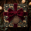 Luxury vintage deer Christmas gift wrap with a burgundy velvet bow and Winter Wishes tag by Wrapped Studios.