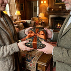 Luxury vintage woodland wrapping paper with copper bow by Wrapped Studios, held by a couple.