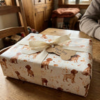 Puppy dog wrapping paper on a gift box with Best Dog Dad tag and ribbon by Wrapped Studios.