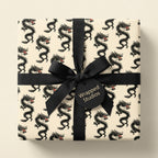 Vintage black dragon wrapping paper on a gift box with a black ribbon by Wrapped Studios.