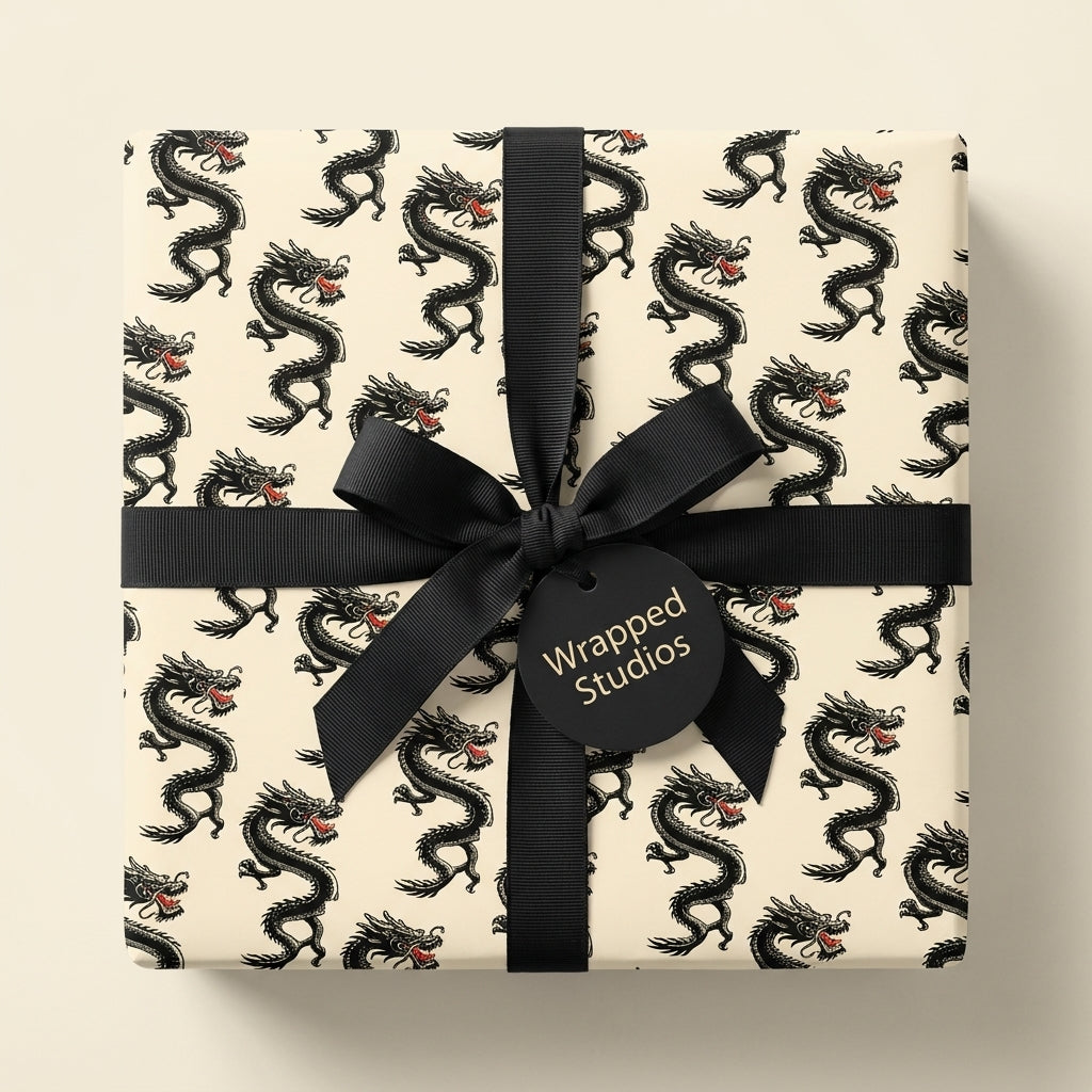 Vintage black dragon wrapping paper on a gift box with a black ribbon by Wrapped Studios.