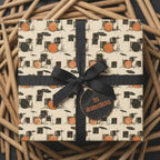 Drummer wrapping paper featuring retro drum set pattern and black bow on a gift box by Wrapped Studios.
