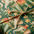 Vintage elephant Christmas wrapping paper in green and gold with a metallic bow by Wrapped Studios.