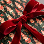 Vintage elf Christmas wrapping paper tied with a red velvet ribbon by Wrapped Studios.