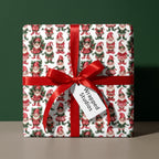 Vintage elf Christmas wrapping paper on a gift box with a red ribbon bow by Wrapped Studios.