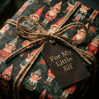 Vintage elf Christmas gift wrap with a rustic twine bow and leather tag by Wrapped Studios.