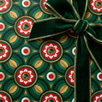 Luxury green and gold Christmas wrapping paper with geometric floral pattern and velvet bow by Wrapped Studios.