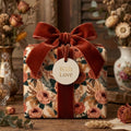 Vintage floral wrapping paper with a terracotta velvet ribbon and 'With Love' tag by Wrapped Studios.