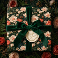 Luxury vintage floral wrapping paper with a green velvet bow and gift tag by Wrapped Studios.