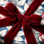 Luxury floral wrapping paper in navy blue tied with a burgundy velvet ribbon bow by Wrapped Studios.