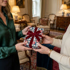 Vintage floral wrapping paper with red velvet ribbon on a gift held by two women, by Wrapped Studios.