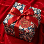 Luxury vintage floral Christmas wrapping paper with a red satin bow on red velvet by Wrapped Studios.