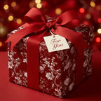 Luxury red floral Christmas wrapping paper with a matching bow and gift tag, by Wrapped Studios.