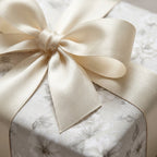 Elegant ivory floral wrapping paper with luxury cream satin bow for weddings, by Wrapped Studios.