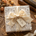 Elegant vintage floral wrapping paper with a cream silk ribbon and 'For You' tag by Wrapped Studios.