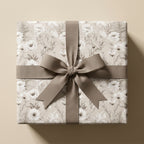 Vintage floral wrapping paper in neutral beige with a taupe ribbon bow by Wrapped Studios.