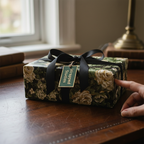Wrapped Studios luxury floral wrapping paper with a black satin ribbon and a gift tag.