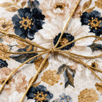 Luxury floral wrapping paper in navy and gold with a metallic bow by Wrapped Studios.
