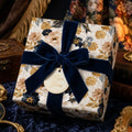 Luxury vintage floral wrapping paper with a navy velvet bow on a gift box by Wrapped Studios.