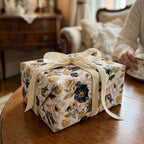 Luxury floral wrapping paper in navy and gold with a cream velvet bow by Wrapped Studios.