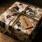 Rustic vintage floral wrapping paper in navy and gold with a No Peeking tag by Wrapped Studios.