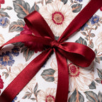 Vintage floral wrapping paper with a burgundy satin bow by Wrapped Studios.