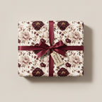 Elegant gift wrapped in floral wrapping paper with burgundy ribbon.