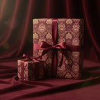 Elegant gifts wrapped in burgundy and gold floral wrapping paper with satin ribbon bows.
