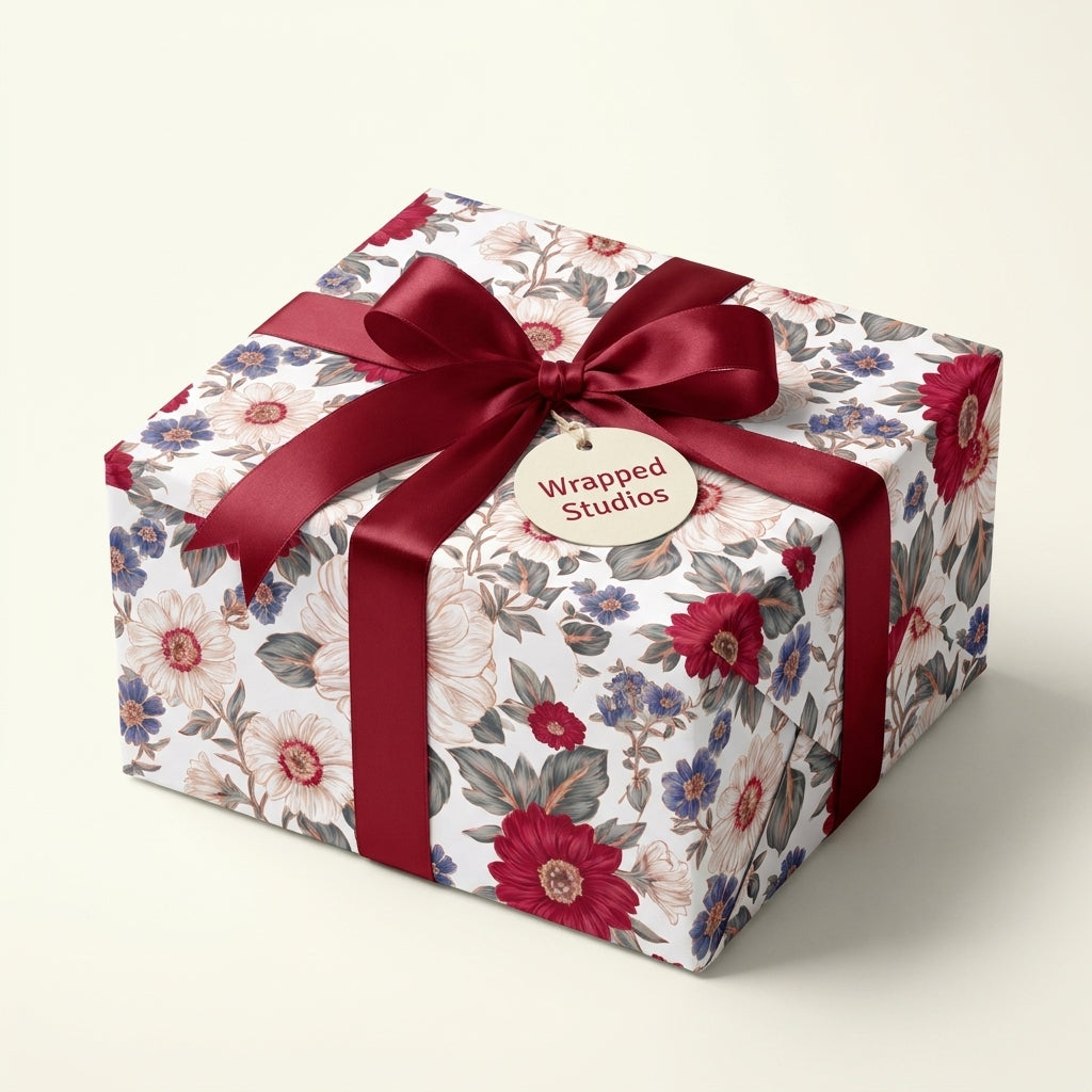 Vintage floral wrapping paper with a burgundy ribbon on a luxury gift box by Wrapped Studios.