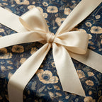 Navy floral wrapping paper with a cream satin ribbon, ideal for luxury gift wrap.