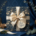 Elegant floral wrapping paper in navy and gold, tied with a satin ribbon and "For You" tag.