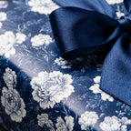 Navy blue vintage floral wrapping paper with a satin ribbon bow. Elegant luxury gift wrap by Wrapped Studios.