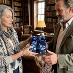 Luxury blue floral wrapping paper with navy ribbon on a gift held by a couple, by Wrapped Studios.