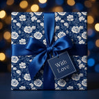 Luxury navy blue floral wrapping paper with a satin bow and "With Love" tag by Wrapped Studios.