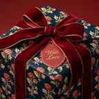 Teal vintage floral wrapping paper with a luxury red velvet bow and gift tag by Wrapped Studios.