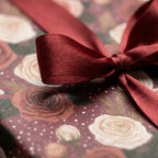 Luxury floral wrapping paper with vintage cream roses and a burgundy satin bow by Wrapped Studios.